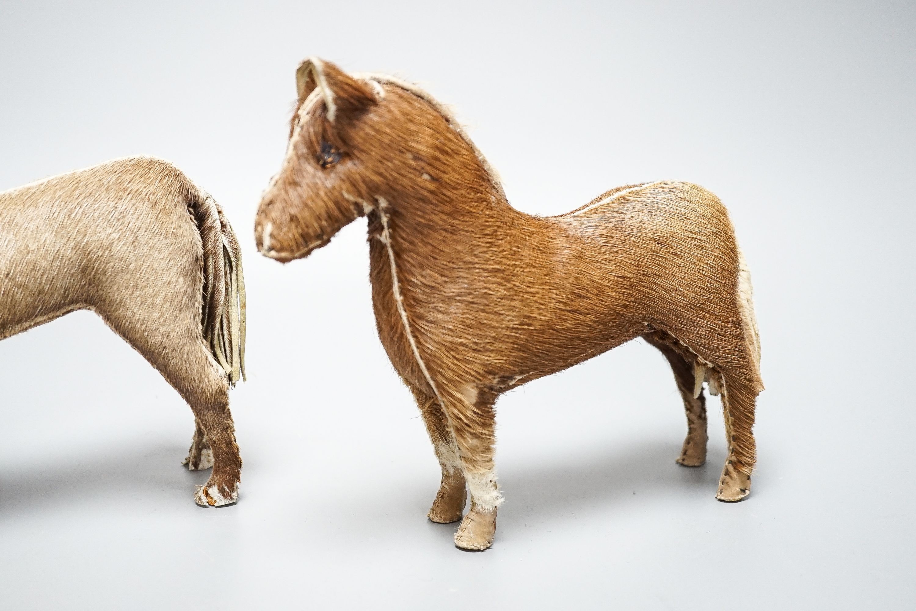 Two Edith Reynolds handmade real skin and leather horse models, 18cm high, together with a female jockey and related leather accessories